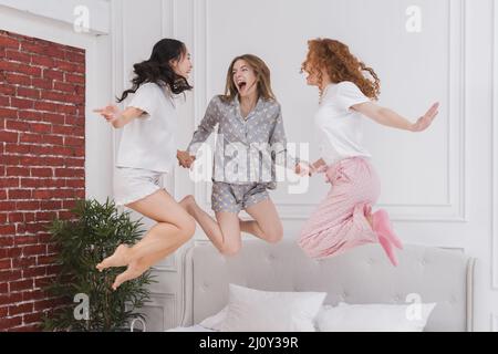 Le giovani amiche saltano a letto. Foto di alta qualità Foto Stock