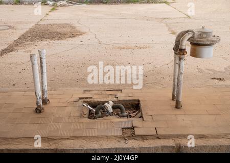 Tubazioni di una pompa del gas strappate in una stazione di servizio abbandonata. Concetto di carburante di crisi Foto Stock