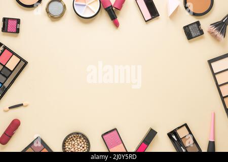 Diversi tipi di cosmetici disperso tavolo beige. Foto di alta qualità Foto Stock