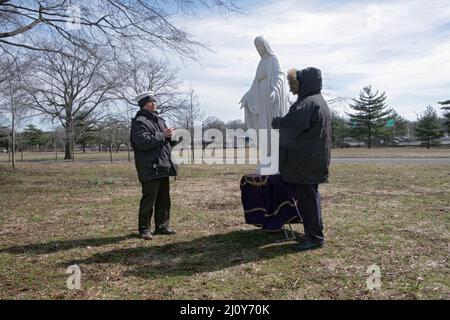 Devoti cattolici romani pregano all'aperto in una fredda giornata invernale nel luogo delle apparizioni di Gesù e Maria di Veronica Lueken. In un parco a Queens, New York Foto Stock