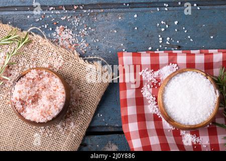 Direttamente sopra il colpo di rosa e bianco sale di roccia in ciotole su tessuto su tavola di legno Foto Stock