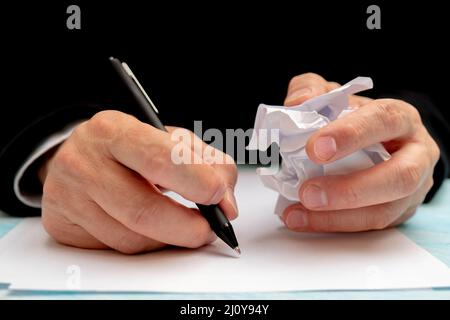 Una penna in una mano d'uomo. Foglio di carta bianco. La firma di un documento. Foto Stock