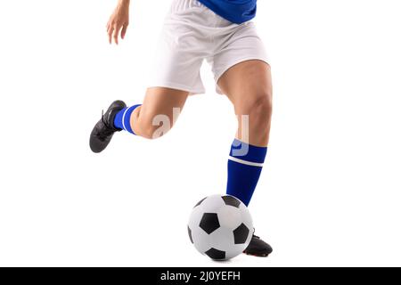 Sezione bassa del giovane femminile biraciale calciatore calci palla di calcio su sfondo bianco Foto Stock