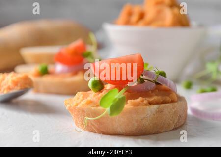 Pezzo di pane con gustoso hummus sul tavolo Foto Stock