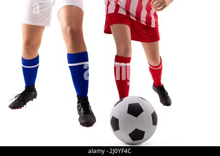 Sezione bassa di giovani donne biraciali e caucasiche che giocano a calcio su sfondo bianco Foto Stock