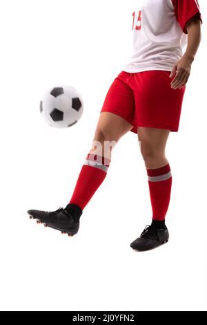 Sezione bassa del giovane femminile biraciale giocatore di calcio giocoleria palla di calcio con piede Foto Stock