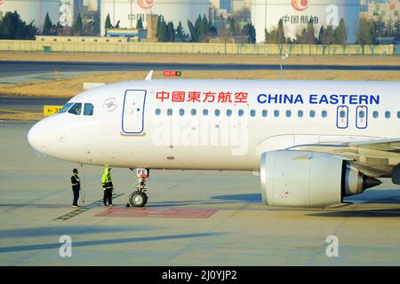 QINGDAO, CINA - 21 FEBBRAIO 2021 - il personale di terra controlla un aereo passeggeri China Eastern Airlines prima che decolli all'aeroporto di Liuting a Qingdao Foto Stock