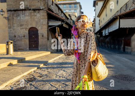 Donna che visita il famoso vecchio ponte, chiamato Ponte Vecchio, a Firenze Foto Stock