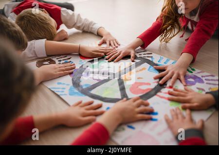 Scolari che fanno il manifesto di segno di pace a scuola. Foto Stock