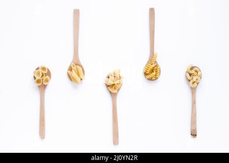 Diversi tipi di pasta cruda italiana cucchiaio di legno superficie bianca. Foto di alta qualità Foto Stock