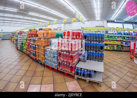Fossano, Italia - 12 marzo 2022: Pallet con bottiglie di bibite e bevande colorate in vendita al supermercato INS discount, INS è un marchio Foto Stock