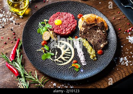 Tartare di manzo da Black Angus. Cipolla, uova di quaglia, salsa di pomodoro, maionese di senape. Delizioso e salutare primo piano di cucina italiana tradizionale servito per pranzo Foto Stock