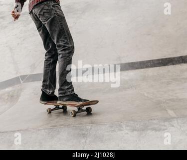 Uomo che si diverte con skateboard all'aperto parco cittadino Foto Stock