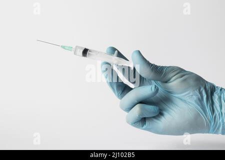 Medico vista frontale con guanti che tengono la siringa Foto Stock