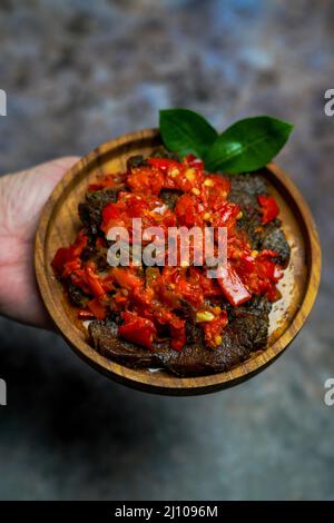 Il Dendeng balado è una cucina tradizionale di Sumatra occidentale, Indonesia, a base di una fetta di manzo con sambal piccante e spezie Foto Stock