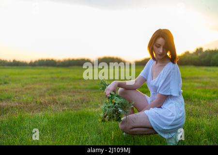 Ritratto di una bella i Capelli rossi ragazza di papaveri prato al tramonto Foto Stock