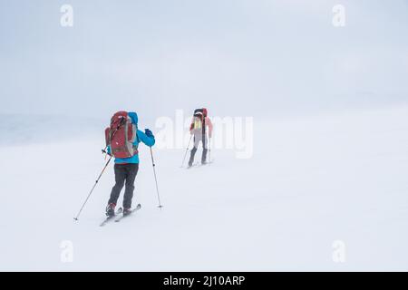 Due sciatori in cattive condizioni Ski Touring nelle montagne della Norvegia Foto Stock