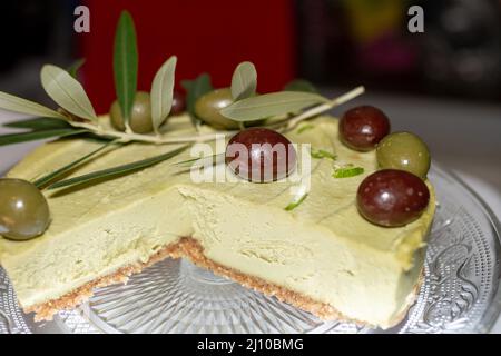 Crostata di avocado con olive su un piatto di vetro. Foto Stock
