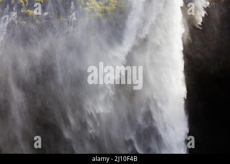 Irrorate in una giornata ventosa, alle Cascate Seljalandsfoss, vicino a Vik, Islanda meridionale. Foto Stock