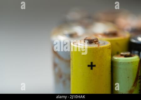 Primo piano della batteria usata con tracce di ruggine e corrosione. Concetto di rifiuti pericolosi elettronici Foto Stock