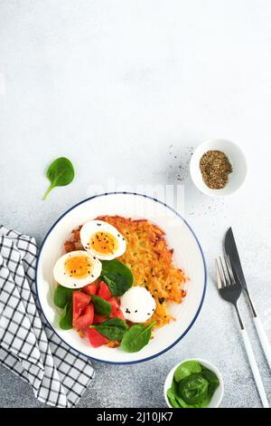 Colazione. Patate al latte con panna acida, insalata di spinaci, pomodori e uova sode su sfondo chiaro. Cibo delizioso per la colazione. Vista dall'alto. Foto Stock