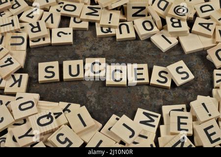 frase 'scess' circondata da lettere su sfondo di ceramica marrone Foto Stock