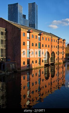 La giustapposizione di vecchia e nuova architettura a Castlefield, Manchester, con il mulino ristrutturato riflesso nelle acque del canale Foto Stock