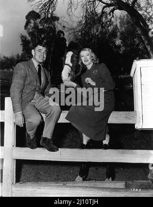 Gli sposi novelli CLARK GABLE e la sua moglie SYLVIA ASHLEY del 4th con IL loro cavallo SONNY al ranch Encino di Gable in California all'inizio del 1950 Pubblicità per Metro Goldwyn Mayer Foto Stock