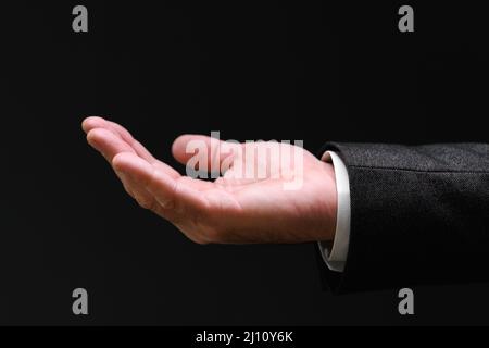 Businessman supplica mano che esce dal fuoco oscuro e selettivo Foto Stock