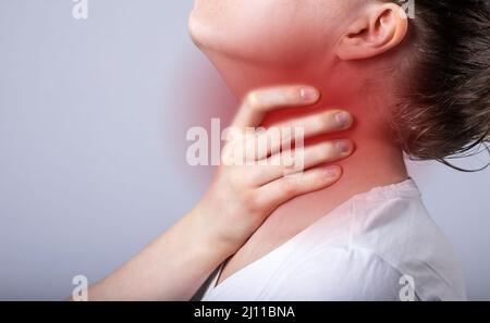 Mal di gola, dolore o dolore al primo piano del collo. Persona che soffre di infiammazione della tiroide. Foto di alta qualità Foto Stock