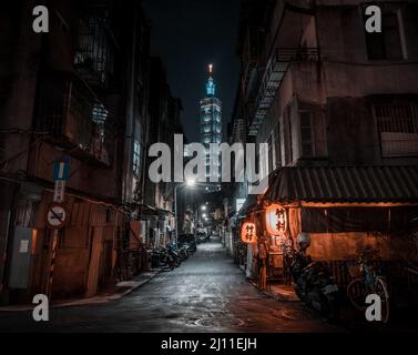 Una vista popolare di Taipei 101 da un vicolo di notte, con un popolare ristorante giapponese izakaya in primo piano. Foto Stock