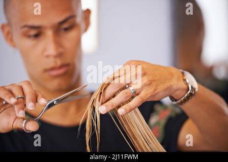 Conosce i capelli. Scatto ritagliato di un parrucchiere maschile che taglia i capelli di un cliente. Foto Stock