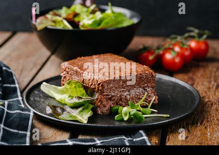 Carne vegana a base di piante crude con erbe aromatiche. Sfondo nero. Vista  dall'alto Foto stock - Alamy