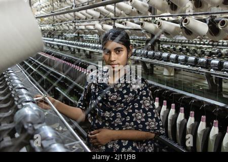 Un operaio sta fissando i fili in una fabbrica tessile a Narayanganj, Bangladesh. L'industria dell'abbigliamento pronto all'uso (RMG) è un pilastro di questa storia di successo economico. Il Bangladesh è oggi uno dei maggiori esportatori mondiali di abbigliamento, con il settore RMG che rappresenta il 84 per cento delle esportazioni del Bangladesh. Bangladesh. Foto Stock