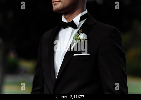 Boutonniere sulla giacca dello sposo. Fiore su una giacca uomo. Uomo in una giacca con un fiore Foto Stock