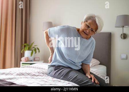 Donna anziana che soffre di mal di schiena Foto Stock