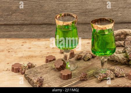 Concetto di giorno di San Patrizio. Cocktail verde tradizionale, cioccolato dolce a forma di foglie di trifoglio, ferro di cavallo, corda d'epoca. Festa tradizionale dicembre Foto Stock