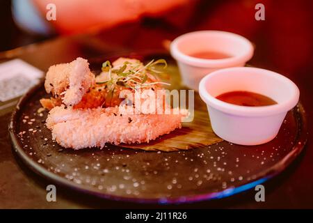 Ali di pollo impanate con due salse messicane Foto Stock