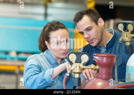 lavoratori che si occupano di bombole di ossigeno blu Foto Stock