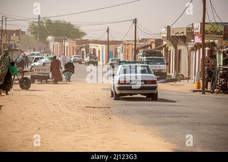 Un'auto su una strada invasa da sabbia deserta, regione di Adrar, Mauritania Foto Stock