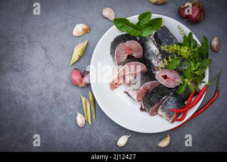 Pesce testa di serpente per la cottura del cibo, pesce testa di serpente a strisce tritato con ingredienti erbe e spezie su piatto bianco e fondo cucina tavolo, ra fresca Foto Stock