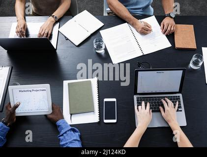 I gadget giusti possono dare un grande impulso alla vostra azienda. Shot di un team di uomini d'affari che utilizzano vari dispositivi tecnologici nel loro ufficio. Foto Stock