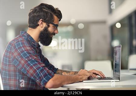 Seguendo le mie passioni mentre facendo una vita grande. Scatto di un giovane designer che lavora sul suo laptop. Foto Stock