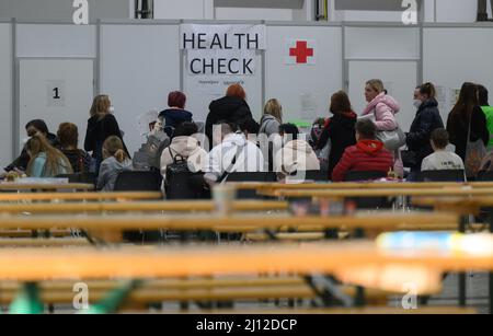 Dresda, Germania. 21st Mar 2022. I rifugiati ucraini attendono i controlli sanitari presso il centro di arrivo di Dresda nel centro fieristico. Al centro degli arrivi, le persone ricevono informazioni, consigli, assistenza medica e alloggi a breve termine. Credit: Robert Michael/dpa-Zentralbild/dpa/Alamy Live News Foto Stock