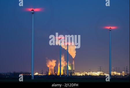 21 marzo 2022, Sassonia-Anhalt, Bad Lauchstädt: Il camino e le torri di raffreddamento della centrale elettrica a lignite di Schkopau stanno fumando dietro un parco eolico. I conflitti bellici stanno rianimando la discussione in Germania sulla graduale eliminazione della lignite e l’espansione delle energie rinnovabili. Foto: Jan Woitas/dpa-Zentralbild/dpa Foto Stock