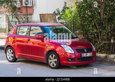 Antalya; Turchia – 04 2022 marzo: Red Suzuki Swift è parcheggiata sulla strada in una giornata calda Foto Stock