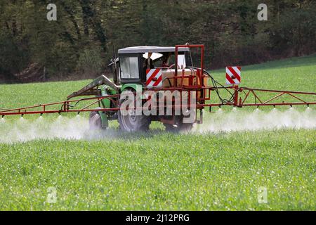 Gli erbicidi vengono spruzzati su un campo con un trattore Foto Stock