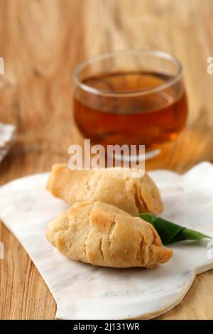 Pisang Molen Goreng, Deep Fried Banana con Sweet Batter Wrap, popolare Street Food indonesiano. Servito con tè Foto Stock