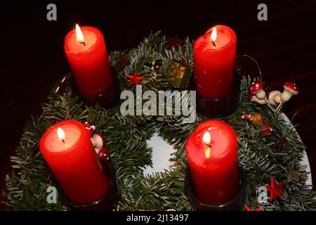 Corona dell'Avvento sul quarto Avvento con 4 candele rosse che bruciano Foto Stock