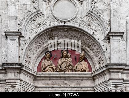 Parte della facciata in marmo con rilievo in terracotta nel timpano sopra la porta della rinascimentale chiesa di Sant Agostino, Montepulciano, Siena, Italia Foto Stock